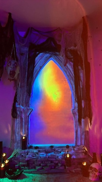 The gothic window glowing orange against violet light.