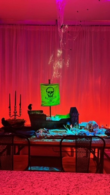The table and curtains under a deep red wash of light.