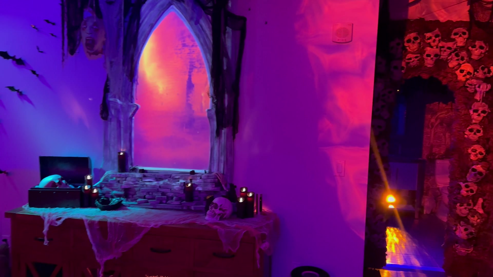 The 2023 gothic window and skull-covered doorway under violet and red lighting.