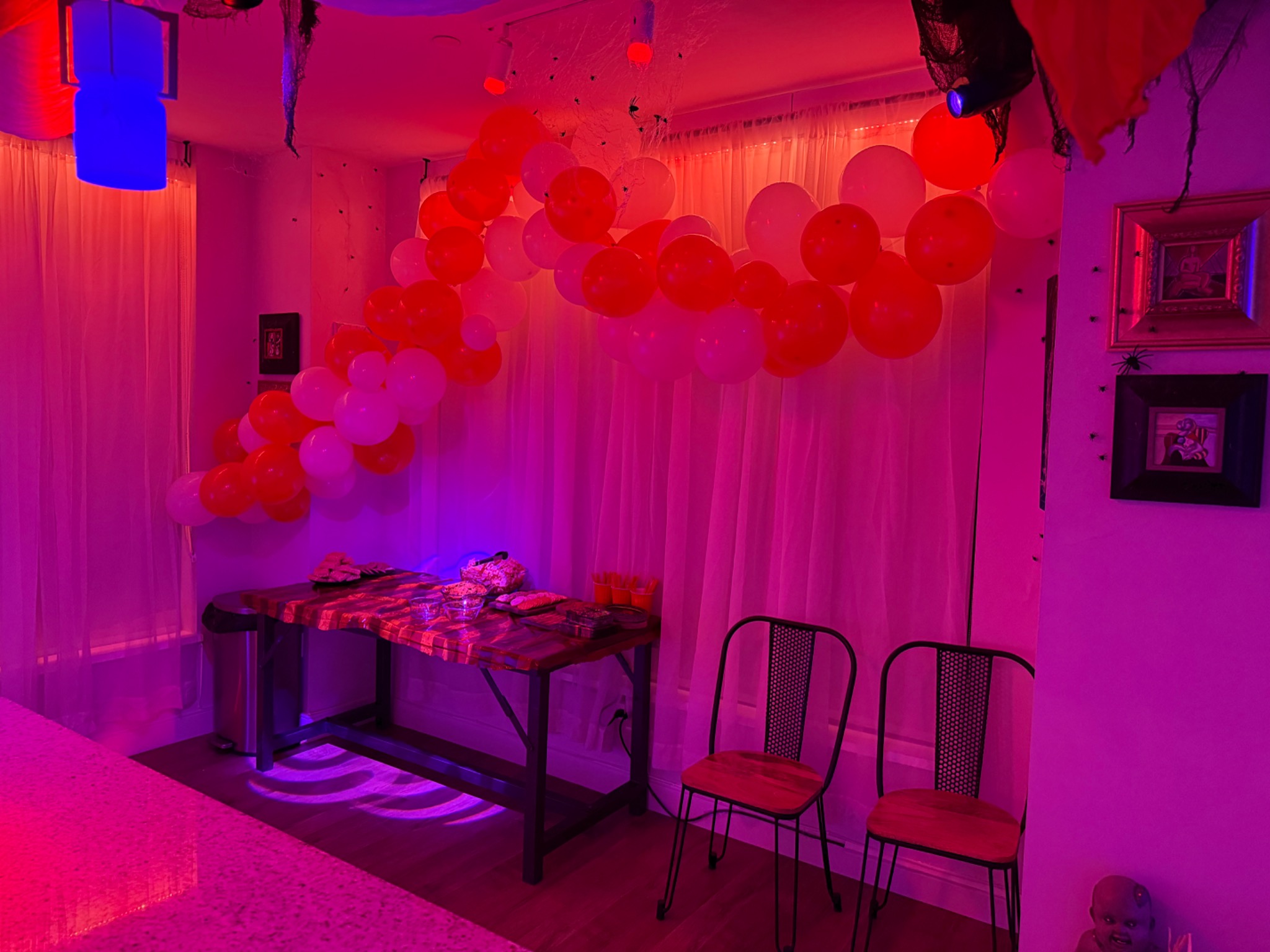 Orange and white balloons sweep across the curtains.