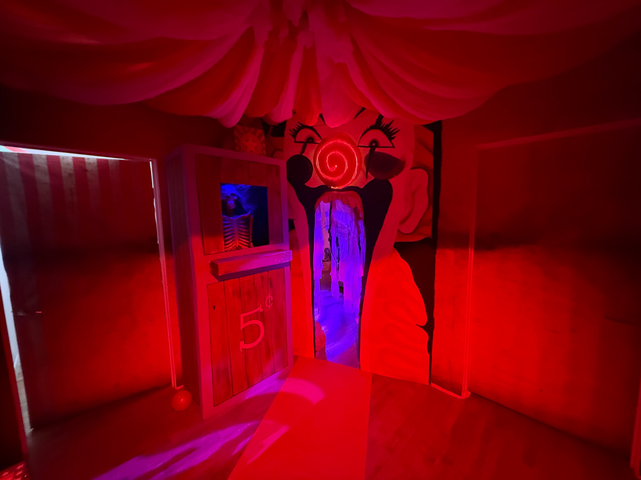 The clown doorway and booth transformed by red and violet light.