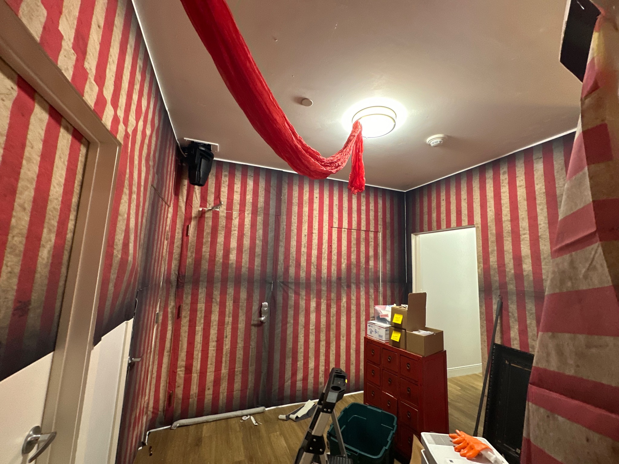 The first red drape goes up overhead.