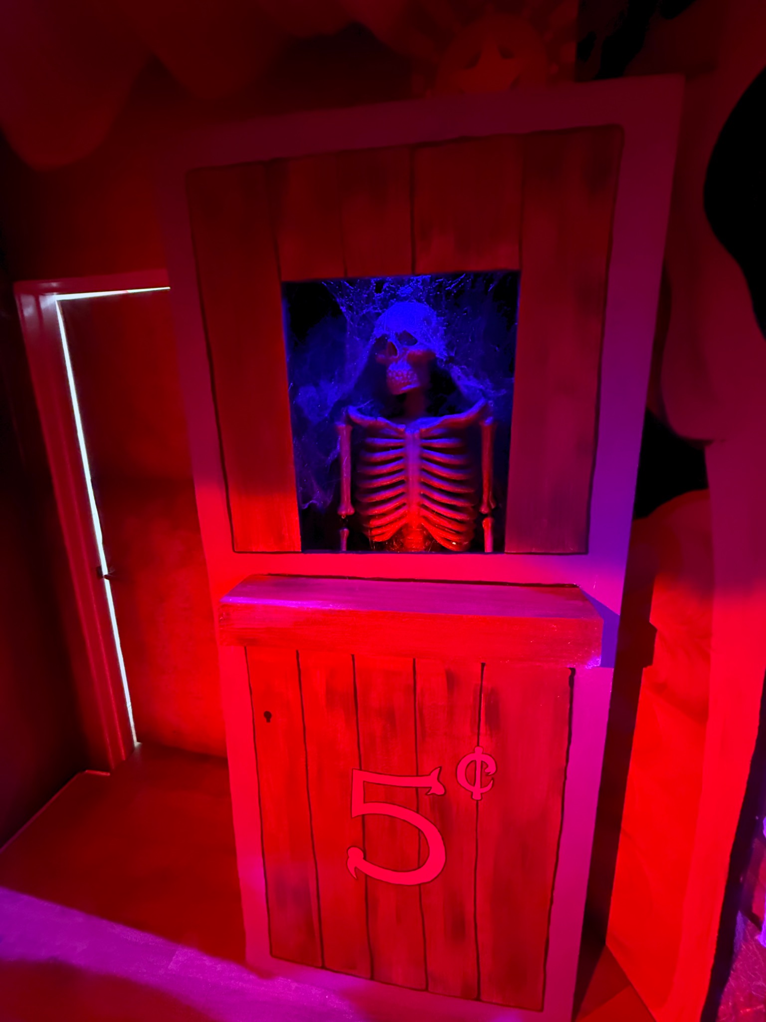 The skeletal fortune teller in the illuminated booth.