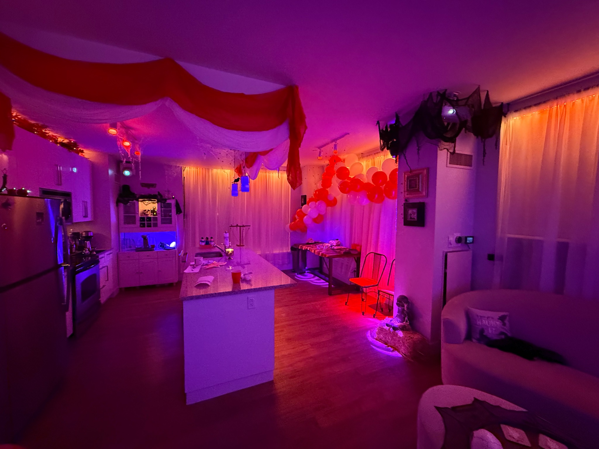 A wide view of the room, with drapery and colored light carrying the theme through.