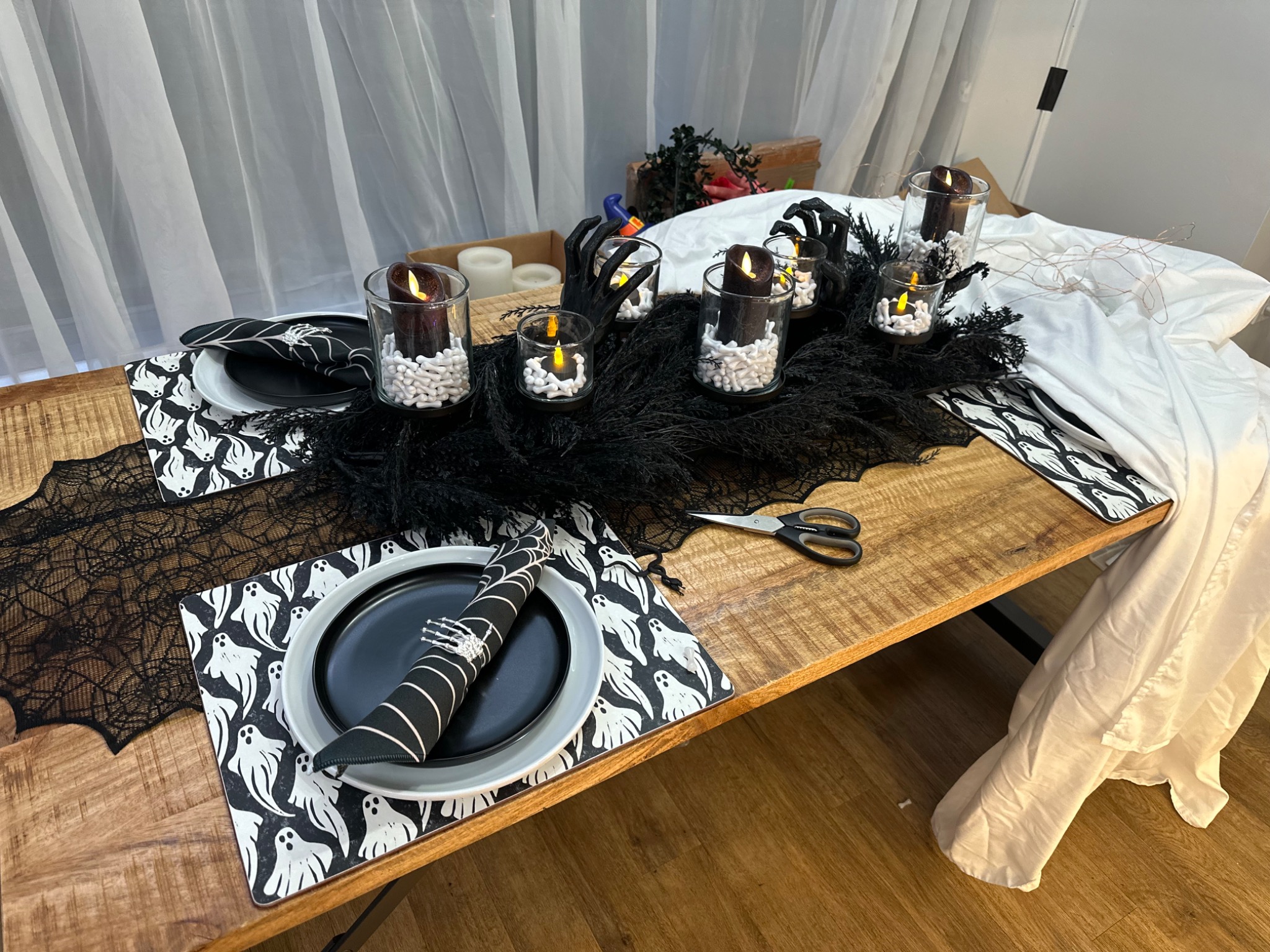 Black plates, patterned linens, and candles in a table-setting test.
