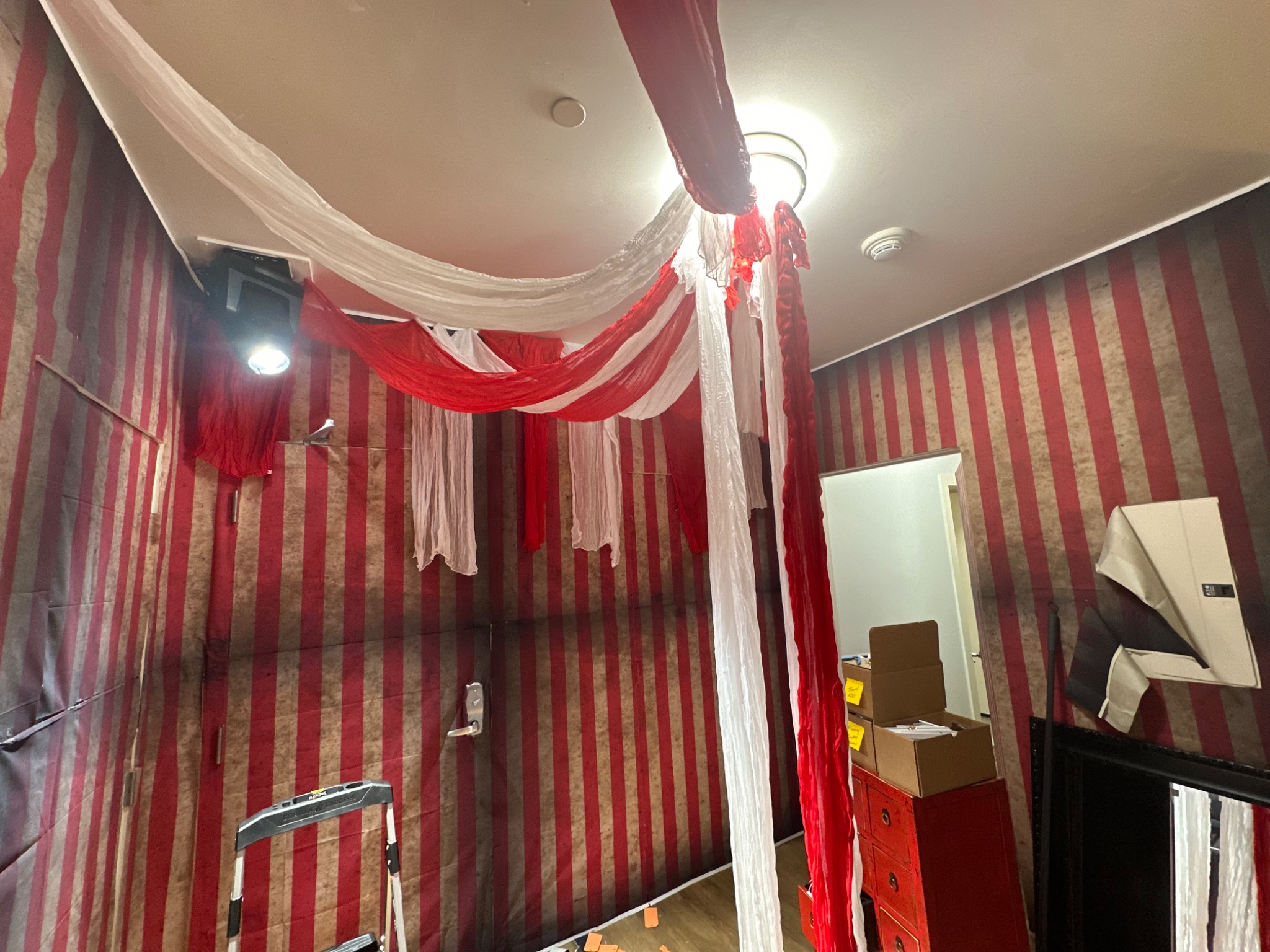 Red and white fabric gathers into a circus-tent ceiling.