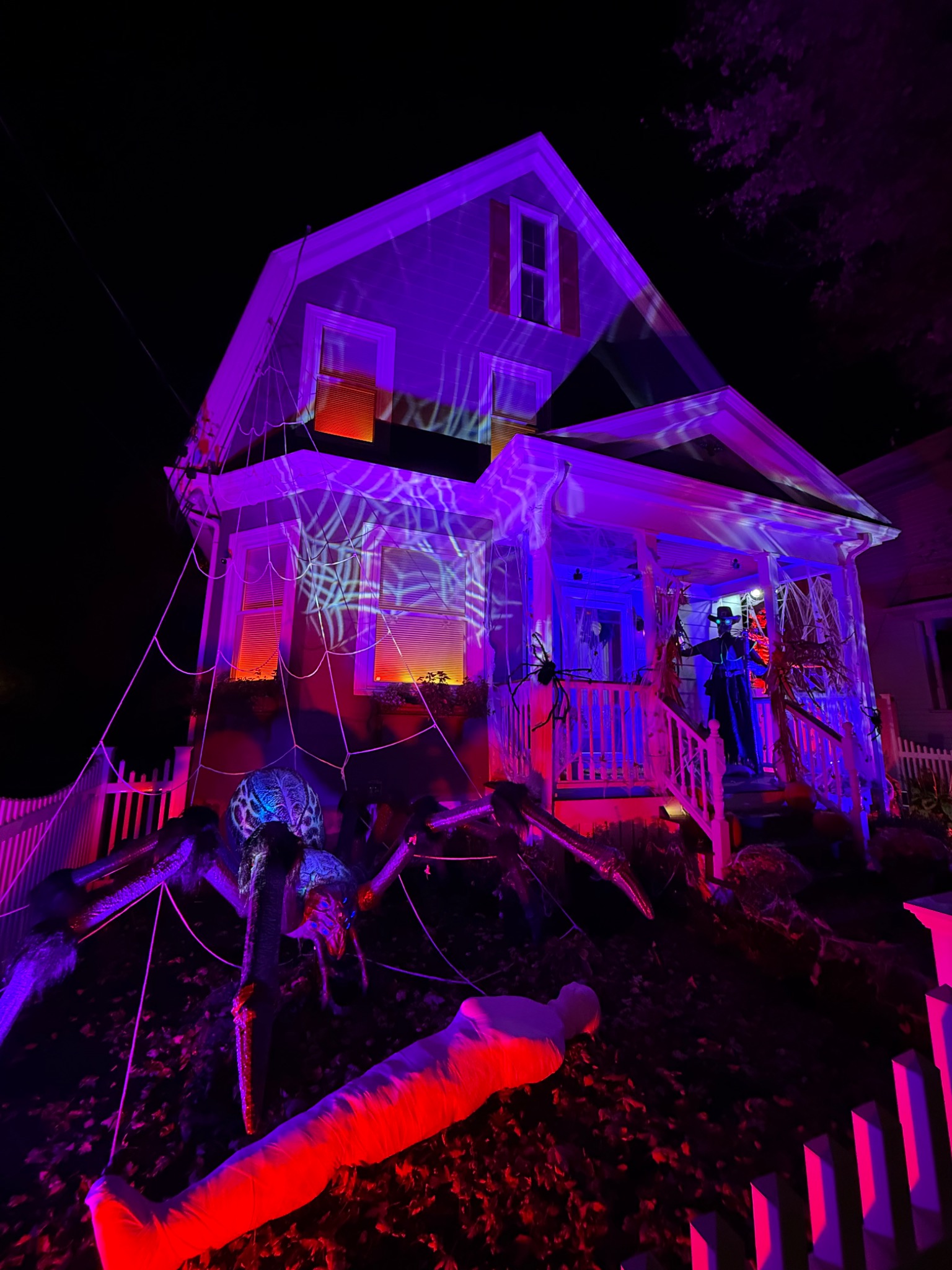 The house covered in web projections, with a giant spider in the yard.