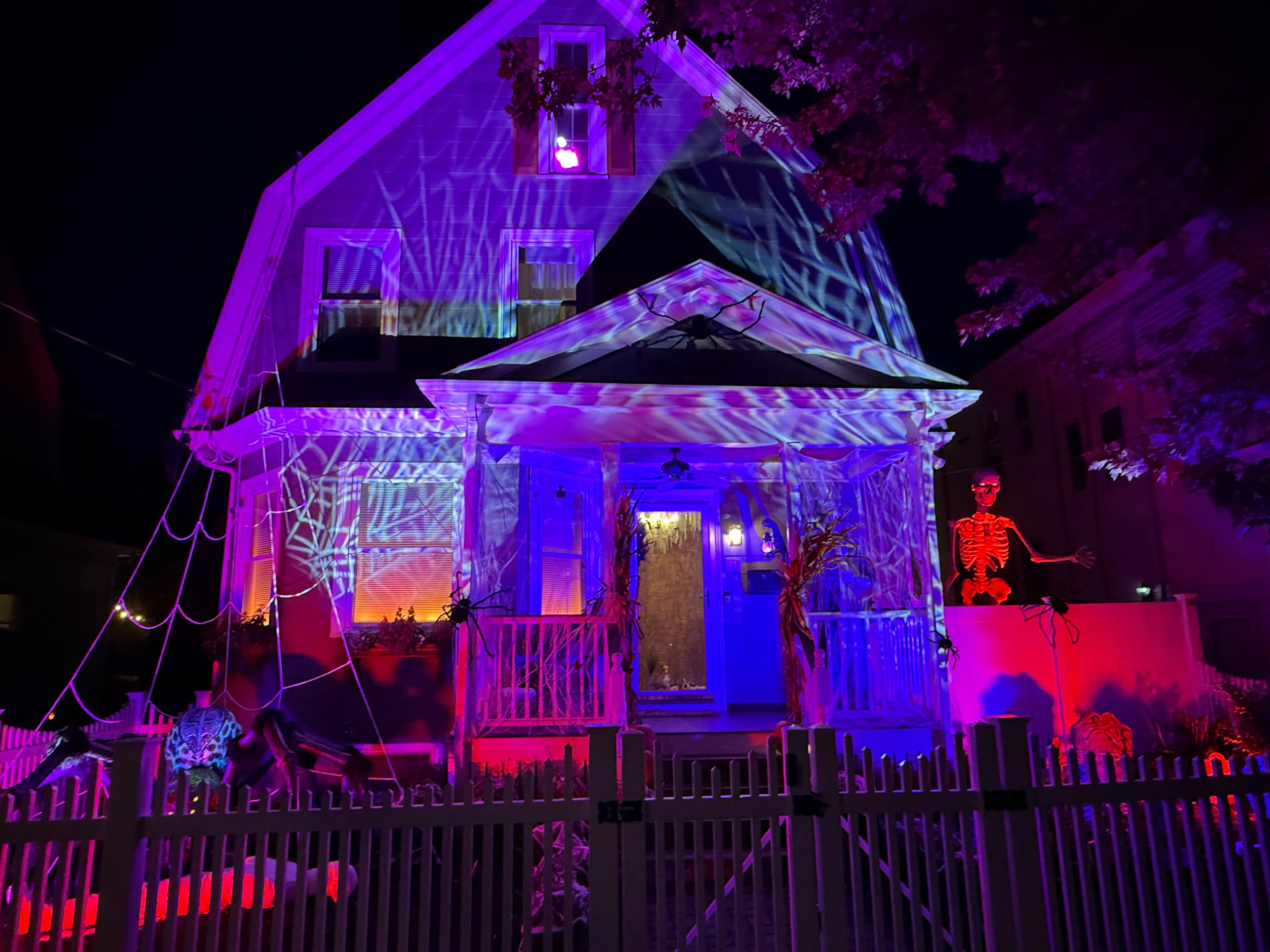 A wide view of the illuminated house and front yard.