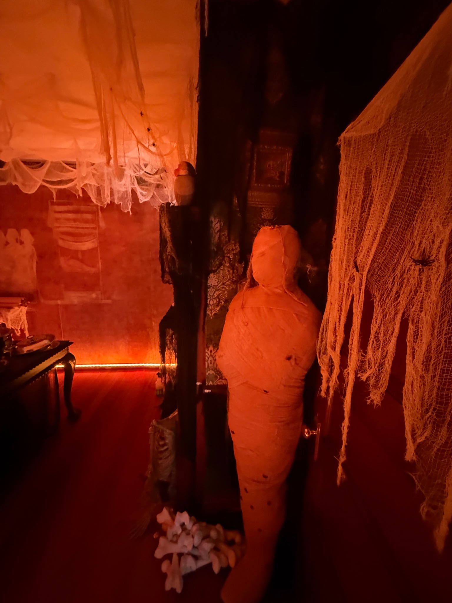 A shrouded mummy beside the tomb entrance.