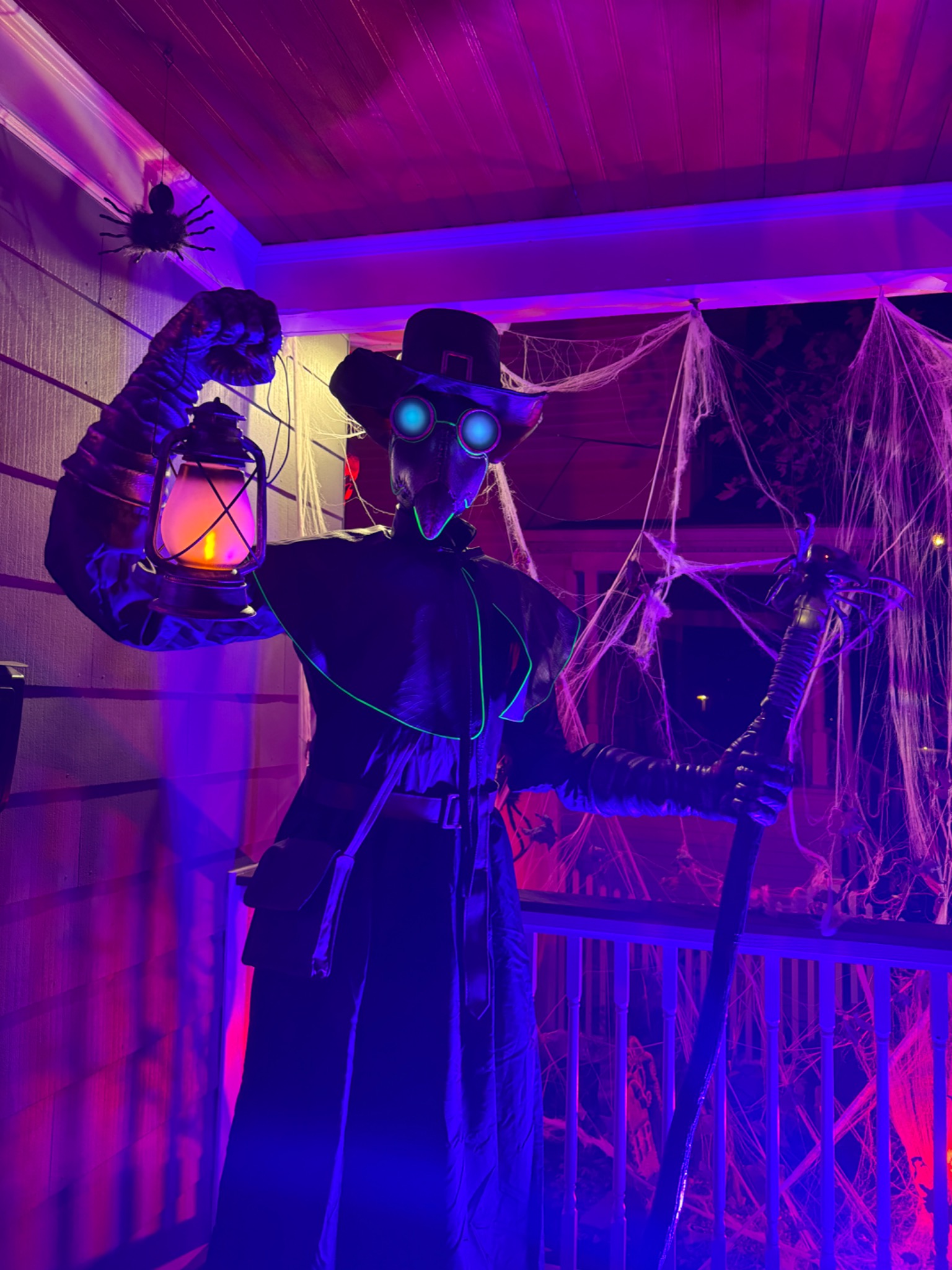A glowing-eyed guardian holding a lantern on the porch.