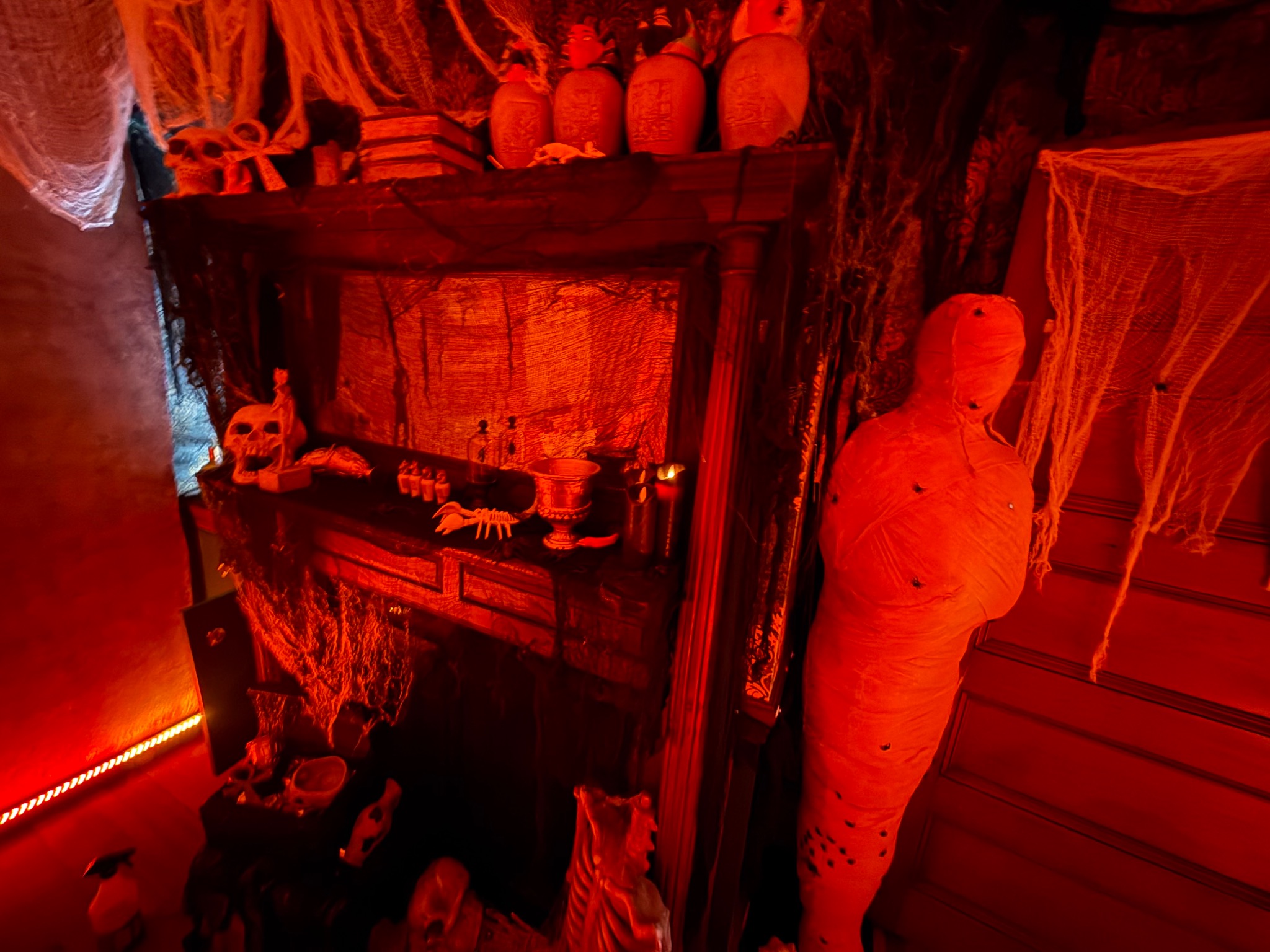 A red-lit display and mummy inside the decorated room.